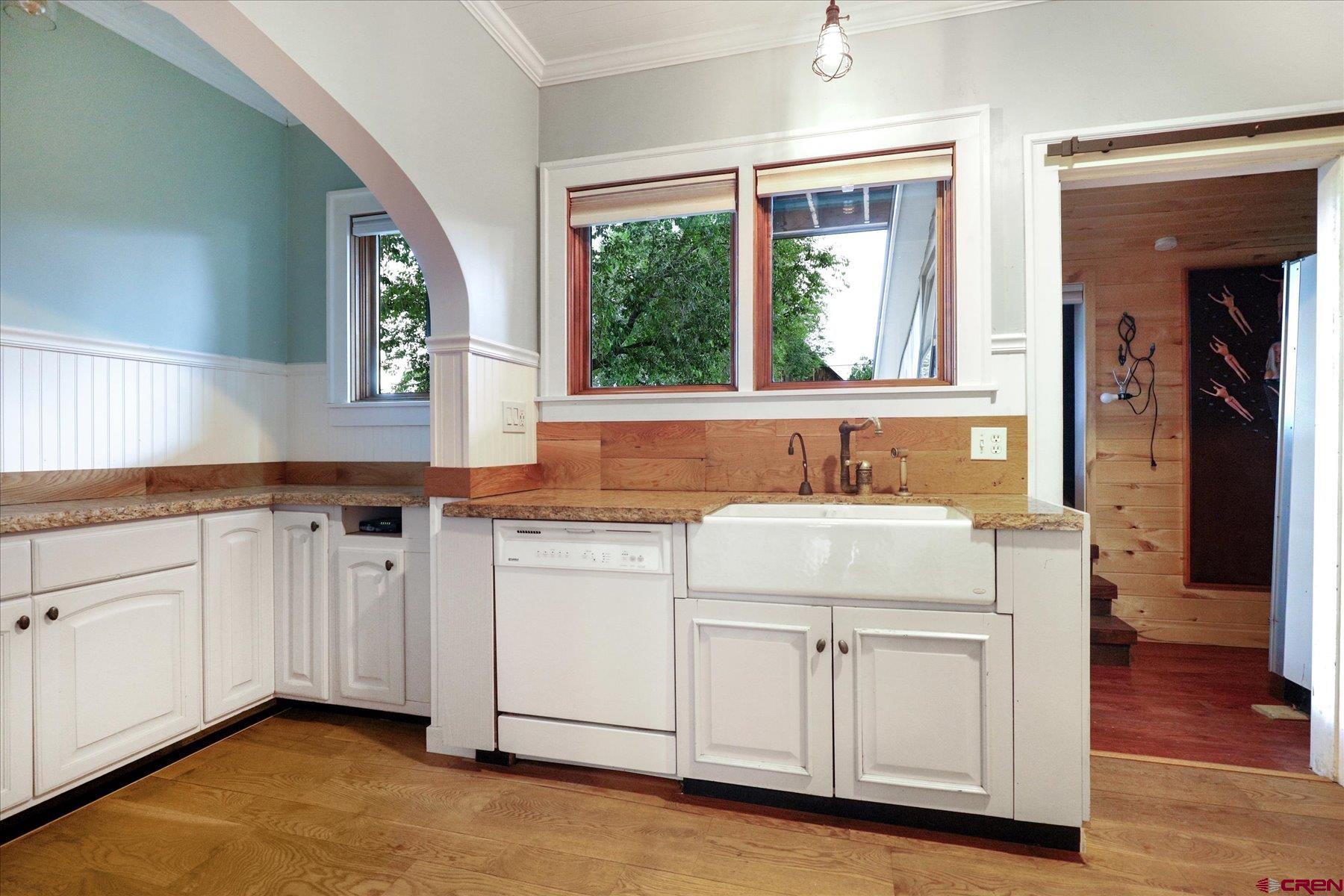 438 Bauer Avenue Mancos, CO 81328 - Photo 9 of 30 a kitchen with granite countertop a sink cabinets and wooden floor