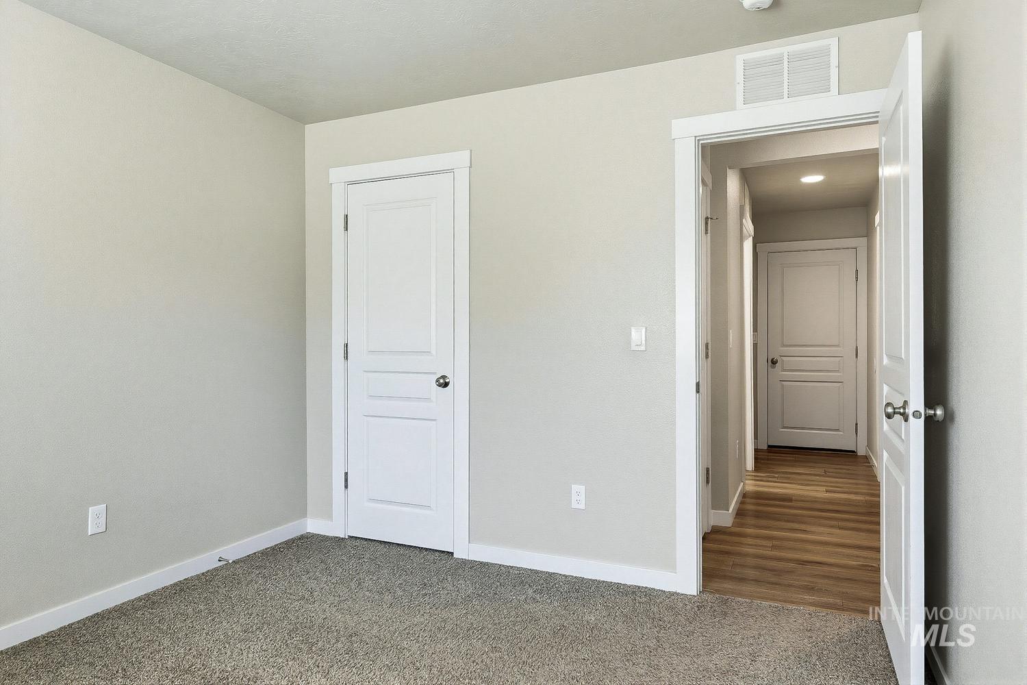 846 North Hidden View Way Star, ID 83669 - Photo 22 of 49 Neutral-toned room featuring plush carpeting, white trim, and a paneled interior door