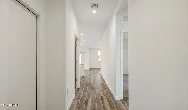 a view of a hallway with wooden floor