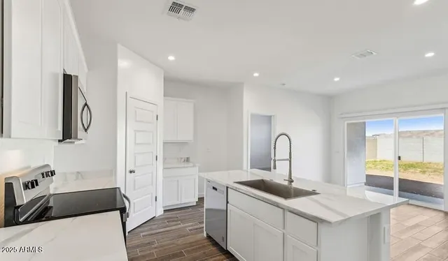 a kitchen with stainless steel appliances granite countertop a sink stove and cabinets