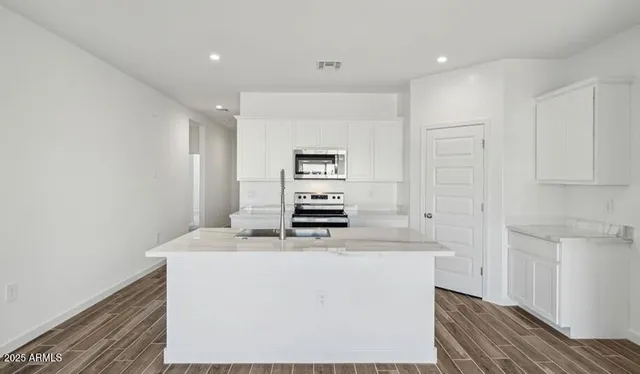 a kitchen with kitchen island a stove a sink and a refrigerator