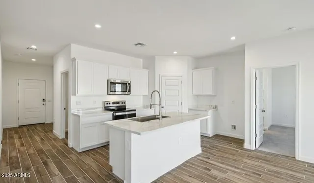 a kitchen with stainless steel appliances granite countertop a sink stove and refrigerator