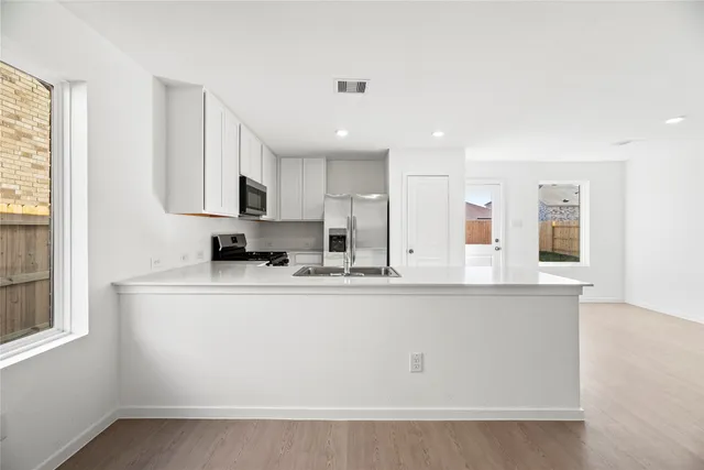 a view of kitchen with stainless steel appliances granite countertop refrigerator sink and stove