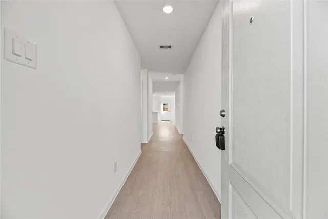 a view of a hallway with wooden floor