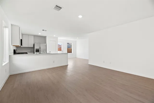 a view of a kitchen with a sink and dishwasher a refrigerator with wooden floor
