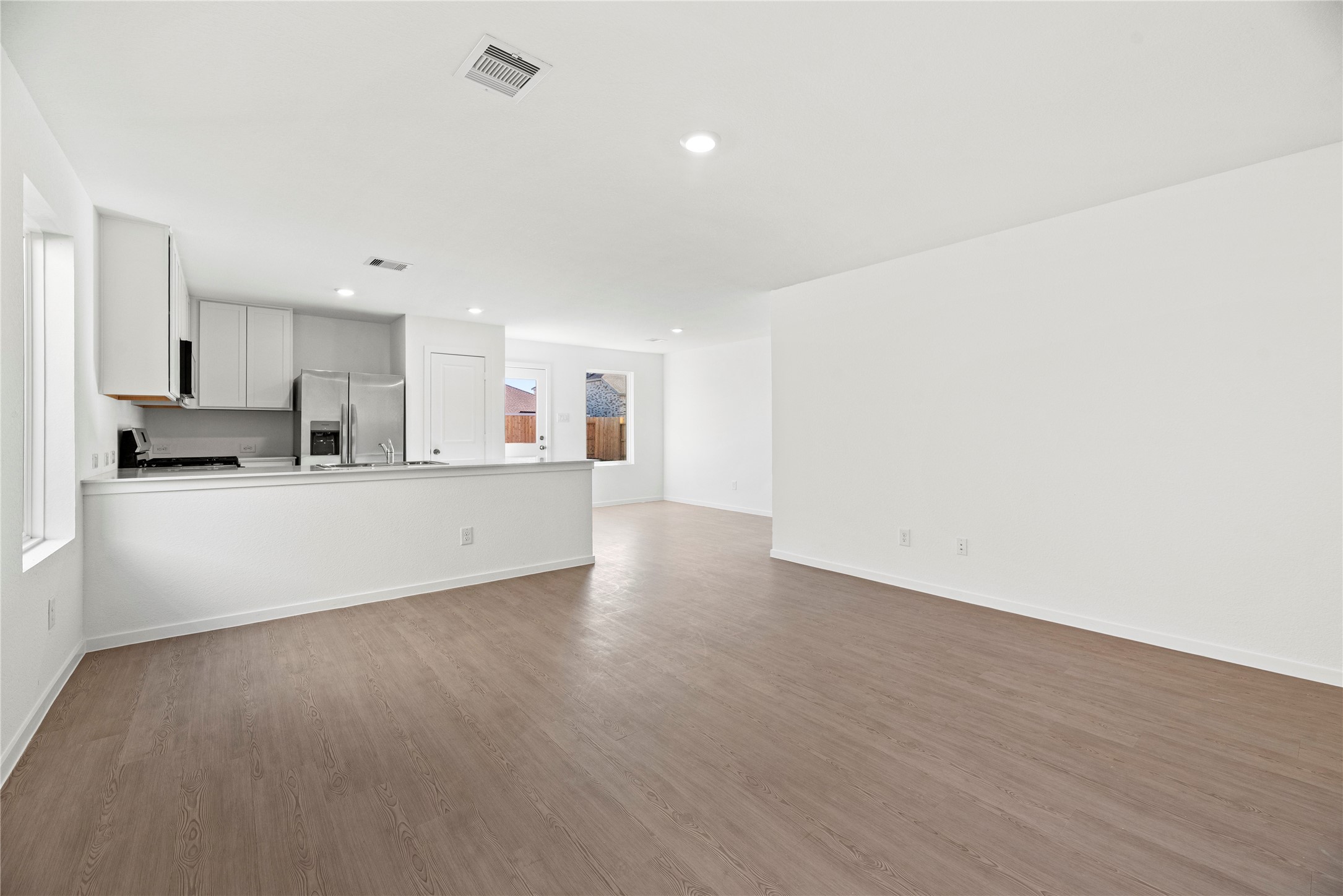 16222 Rustic Prairie Drive Hockley, TX 77447 - Photo 10 of 16 a view of a kitchen with a sink and dishwasher a refrigerator with wooden floor