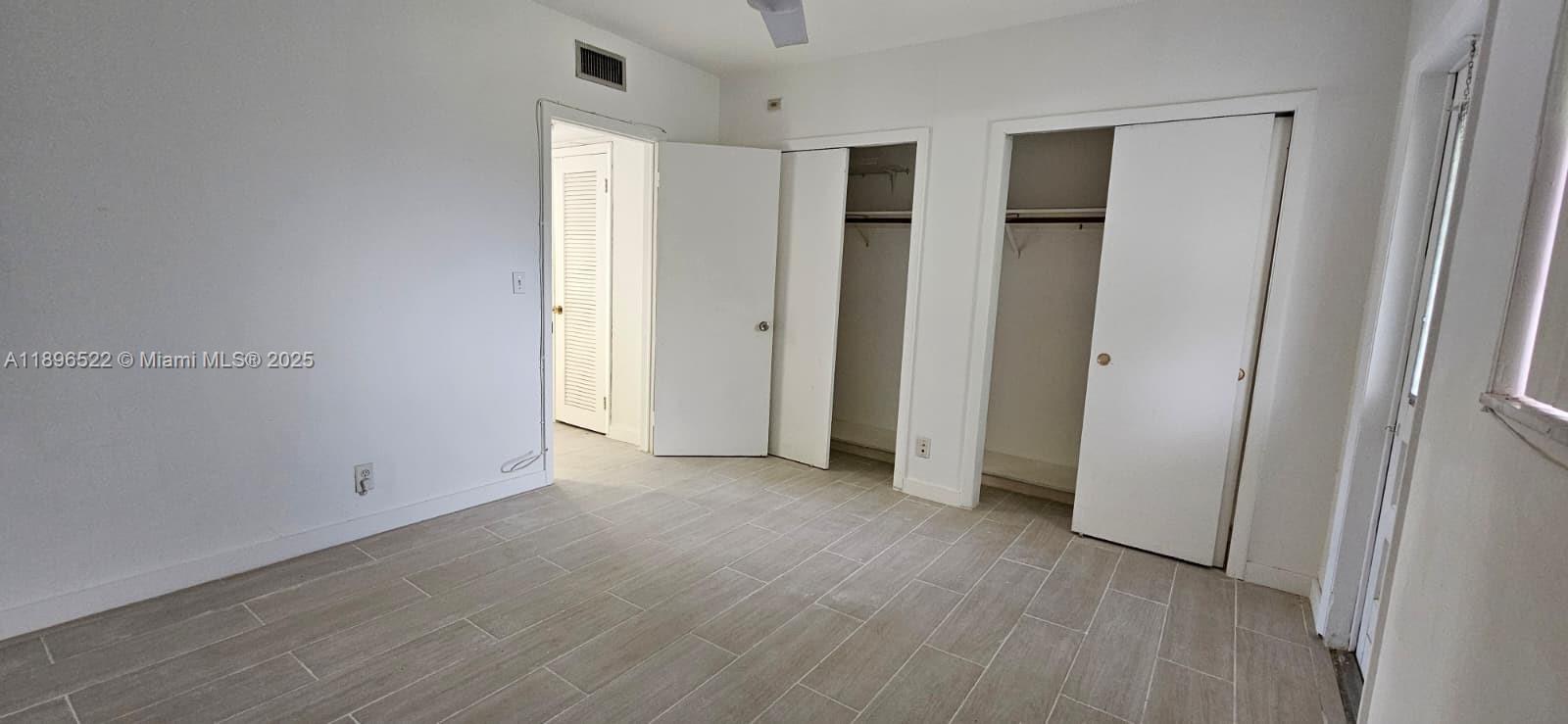 230 Southwest 11th Avenue, Unit 14 Hallandale Beach, FL 33009 - Photo 14 of 20 an empty room with wooden floor and windows