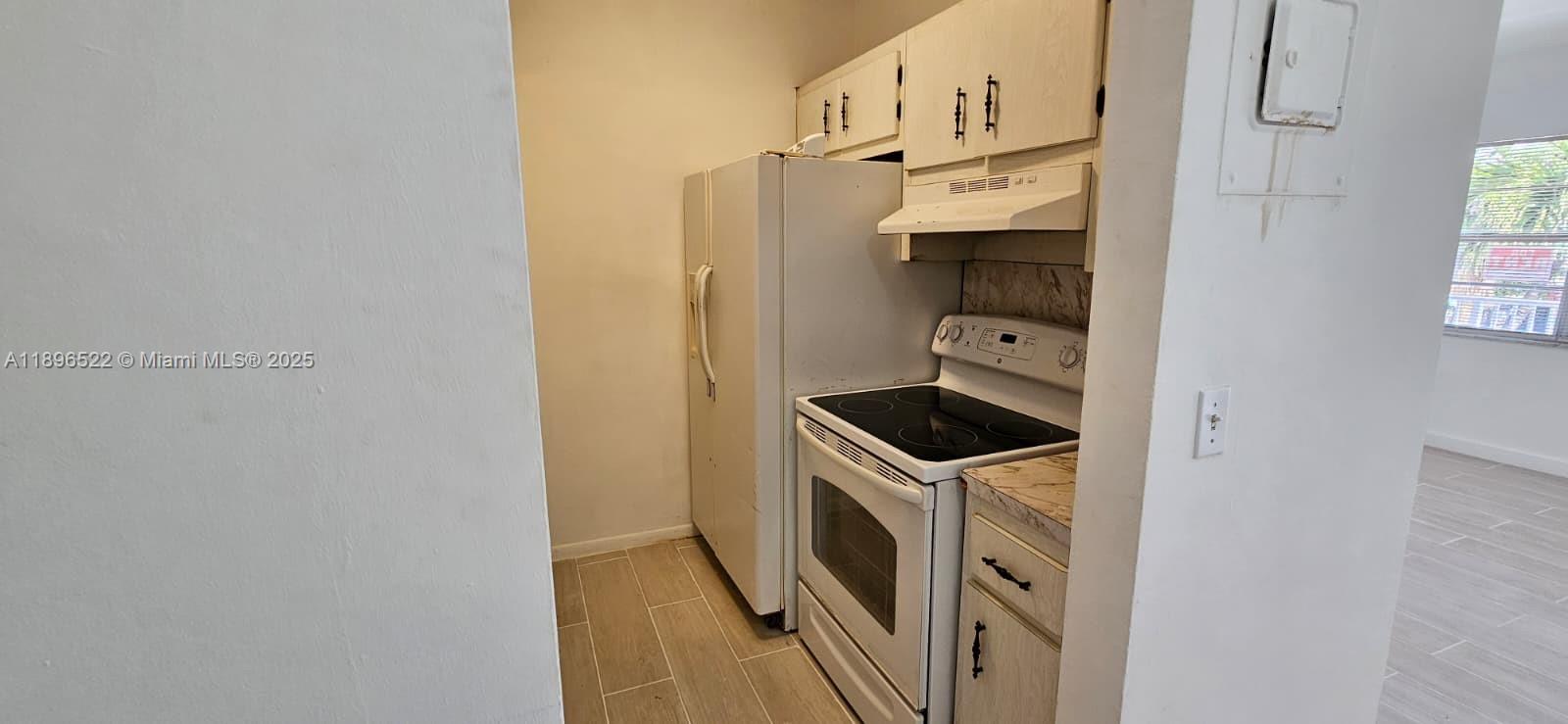 230 Southwest 11th Avenue, Unit 14 Hallandale Beach, FL 33009 - Photo 17 of 20 a kitchen with stainless steel appliances a stove a refrigerator and cabinets