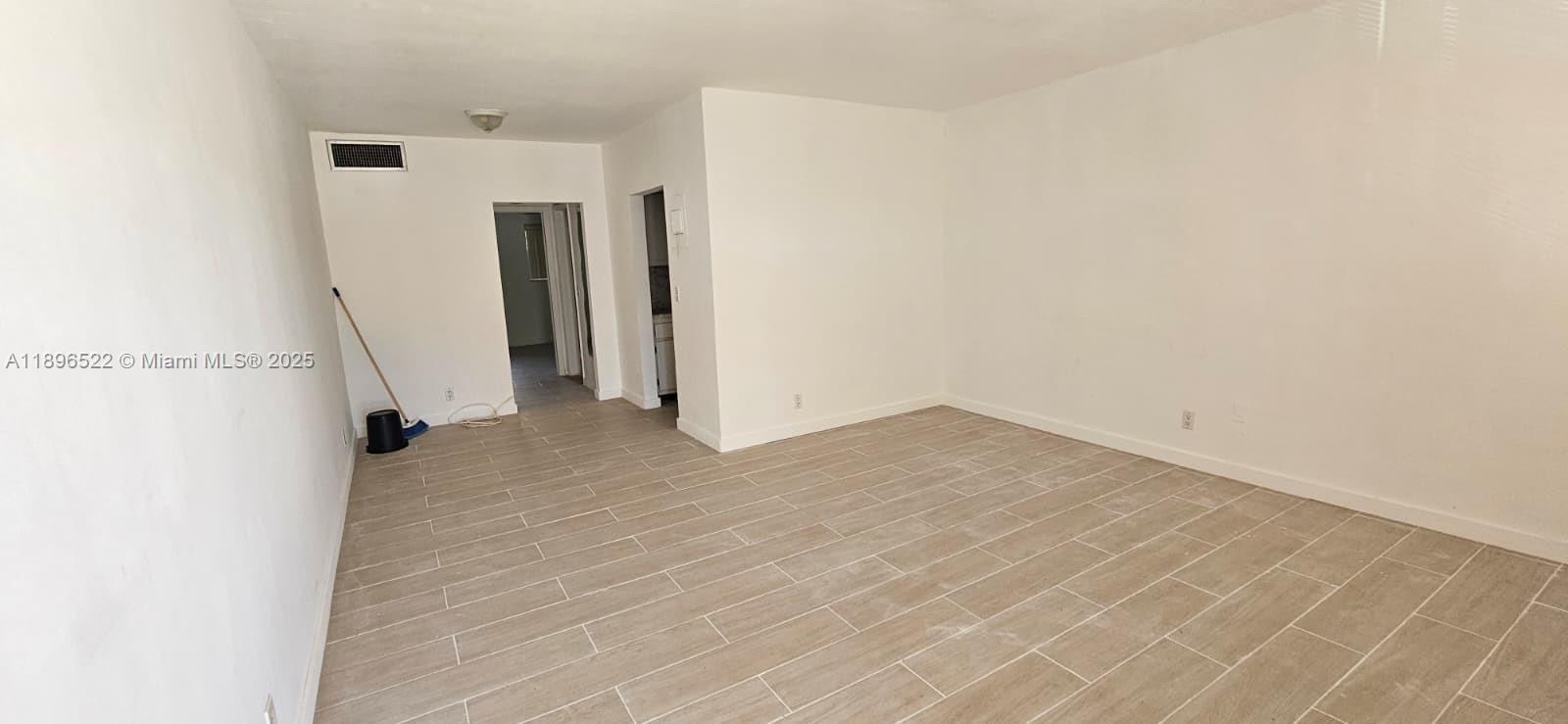 230 Southwest 11th Avenue, Unit 14 Hallandale Beach, FL 33009 - Photo 3 of 20 a view of empty room with wooden floor