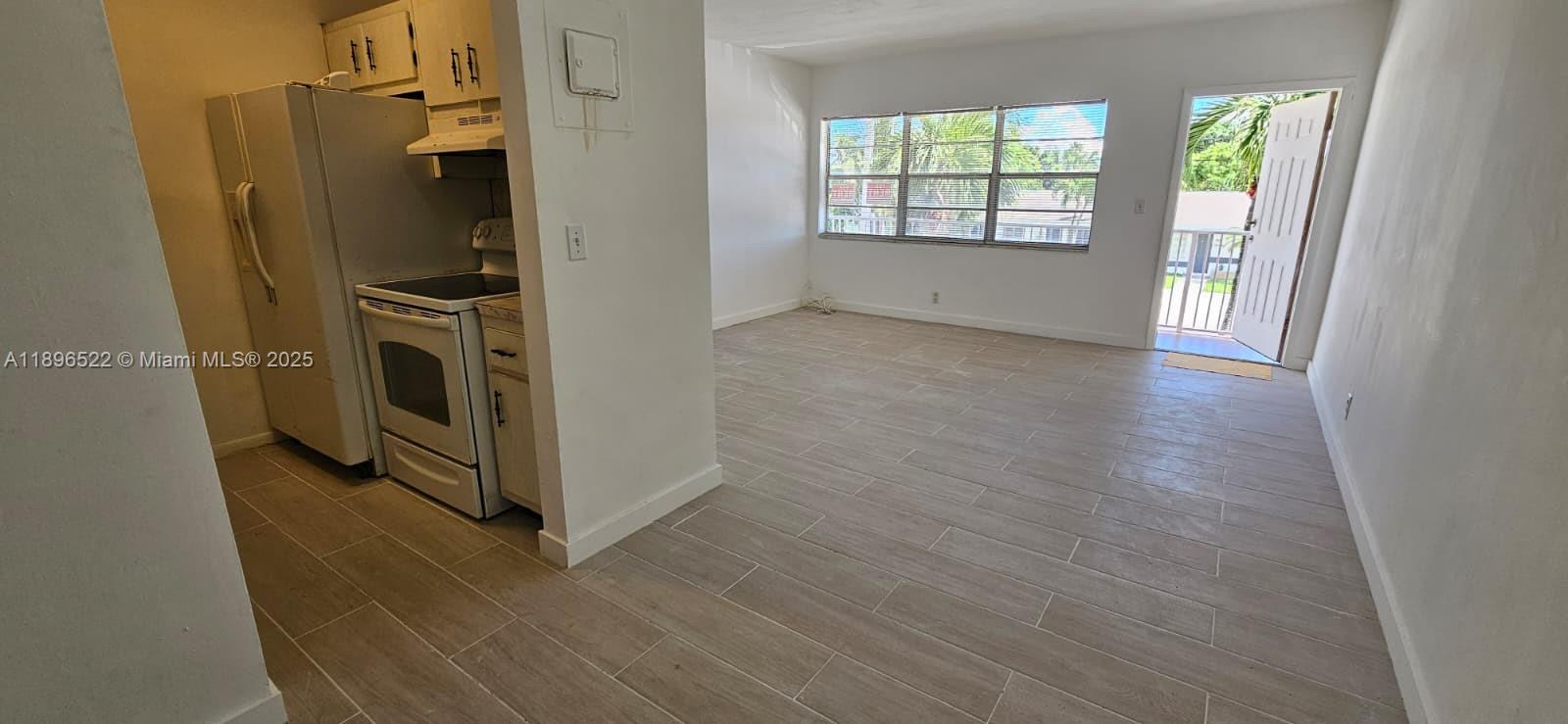 230 Southwest 11th Avenue, Unit 14 Hallandale Beach, FL 33009 - Photo 7 of 20 a kitchen with a refrigerator and window