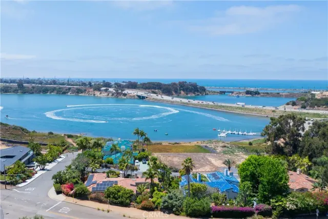 an aerial view of ocean and residential houses with outdoor space