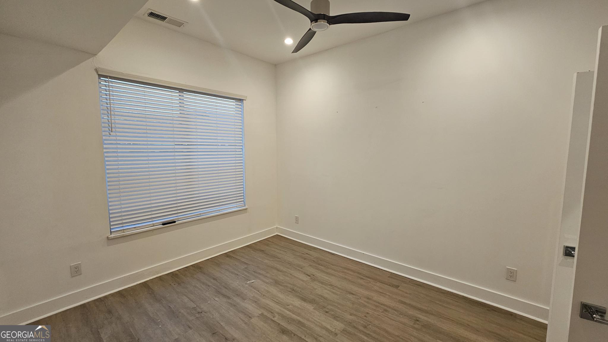 1155 Custer Avenue Southeast, Unit 101 Atlanta, GA 30316 - Photo 21 of 27 an empty room with wooden floor and windows