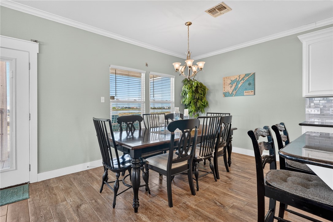 838 Rattlesnake Point Road Rockport, TX 78382 - Photo 14 of 40 a view of a dining room with furniture wooden floor and chandelier