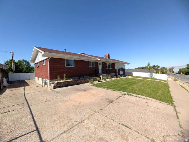 360 400 North Centerville, UT 84014 - Photo 5 of 30 Brick exterior residence featuring a white vinyl fence, established front lawn, and concrete driveway