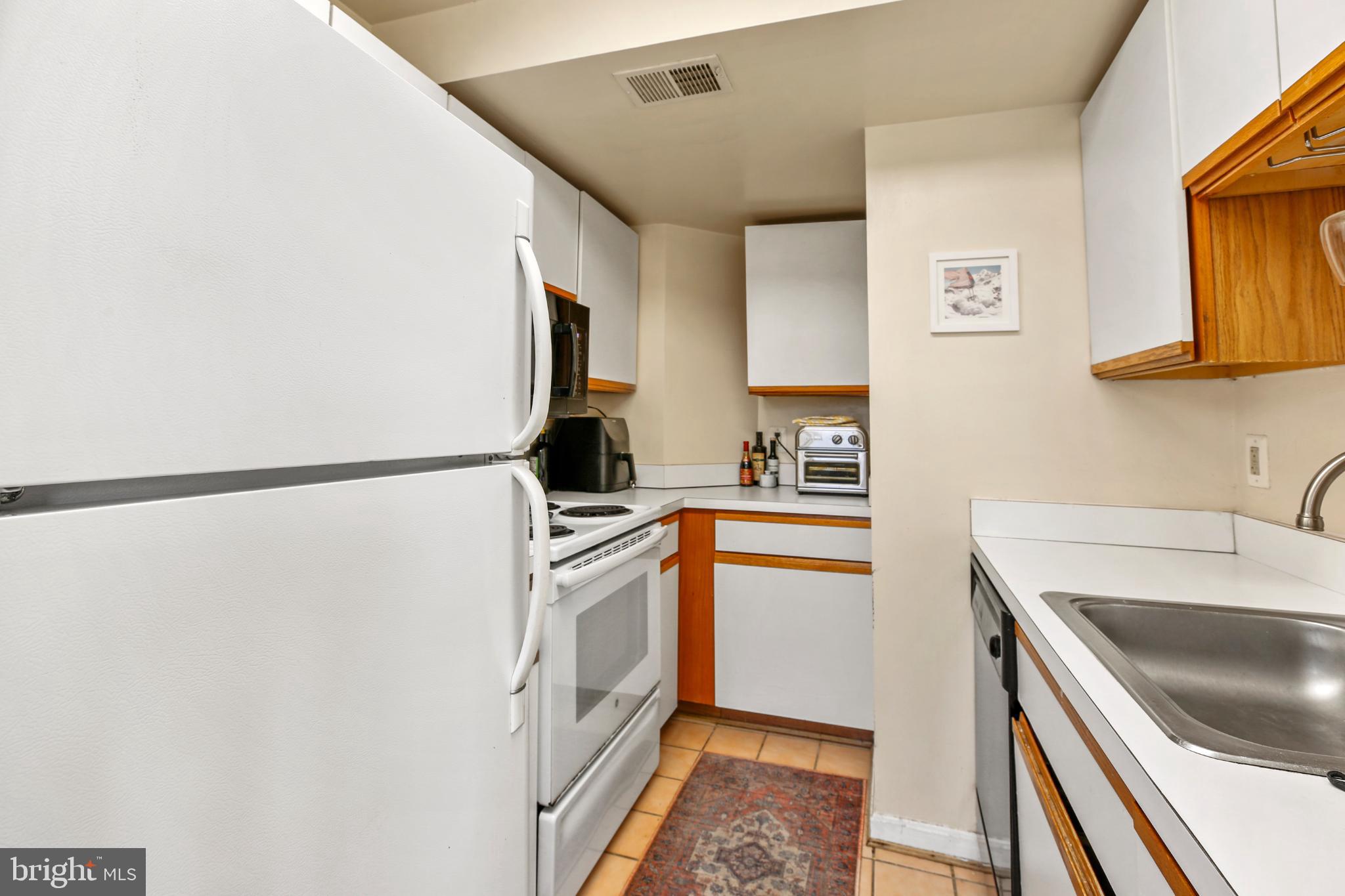 1920 S Street Northwest, Unit 404 Washington, DC 20009 - Photo 11 of 25 a kitchen with stainless steel appliances granite countertop a sink stove and refrigerator