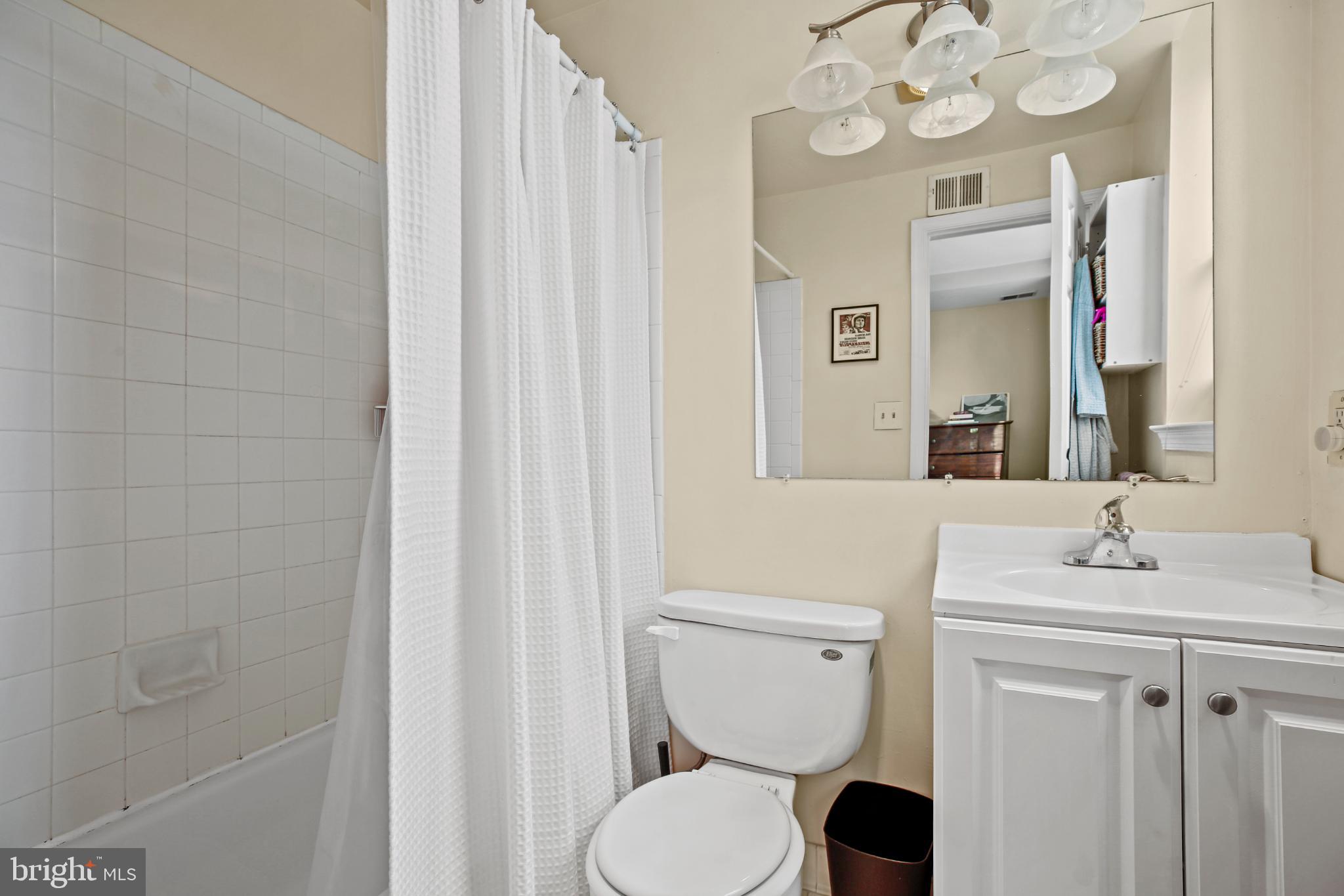 1920 S Street Northwest, Unit 404 Washington, DC 20009 - Photo 19 of 25 a bathroom with a toilet a sink and a mirror