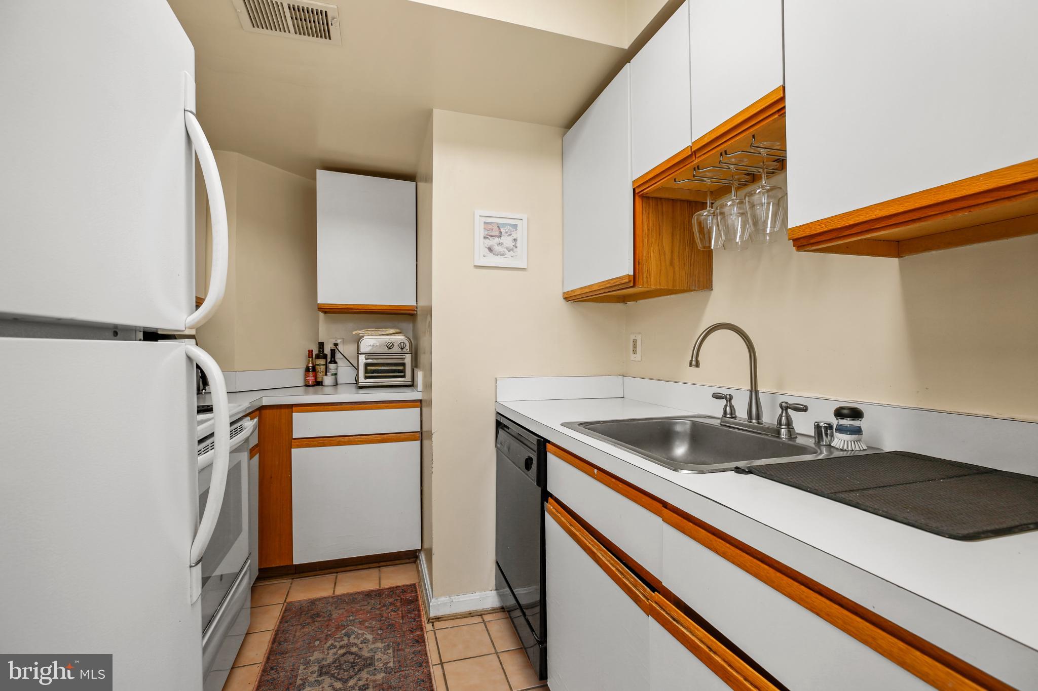1920 S Street Northwest, Unit 404 Washington, DC 20009 - Photo 10 of 25 a kitchen with stainless steel appliances granite countertop a sink and a refrigerator