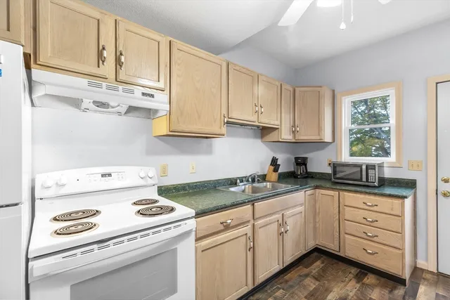 a kitchen with cabinets appliances a sink and a window