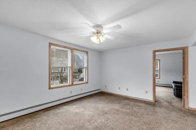an empty room with windows and fan