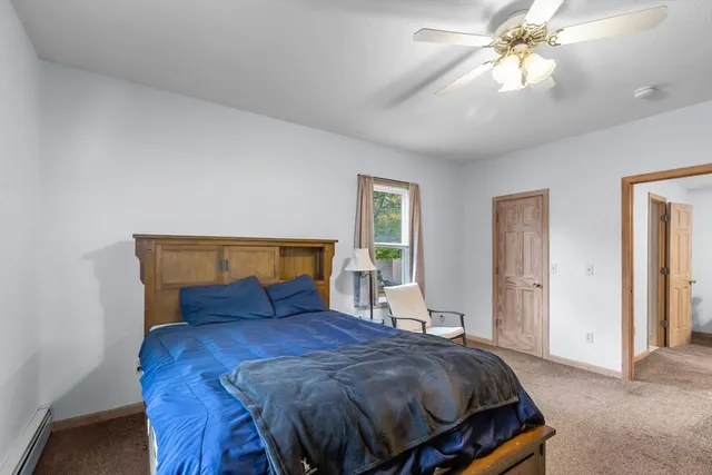 a bedroom with a bed a chandelier and a window