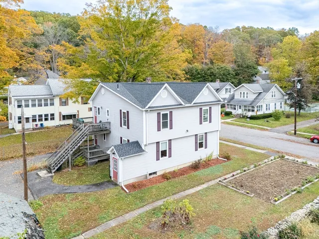 a view of a house with a big yard and large trees