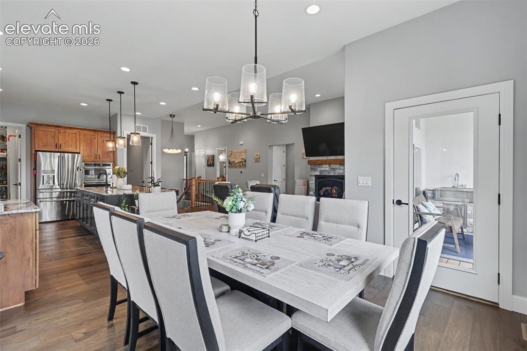 21 Leaming Road Colorado Springs, CO 80906 - Photo 19 of 48 Spacious dining area featuring hardwood flooring, a modern chandelier, recessed lighting, and a glass-paneled door