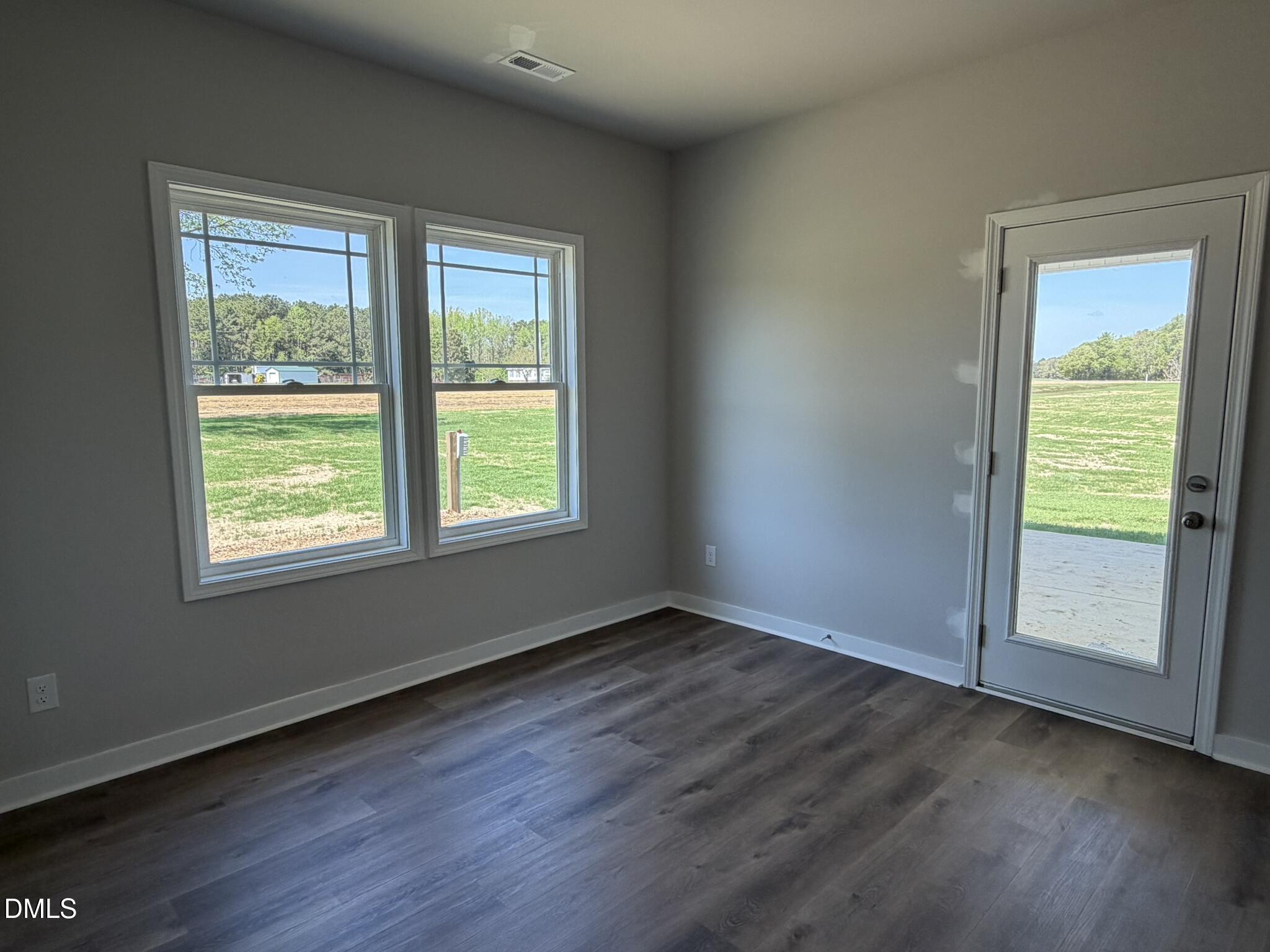 25 Jacobs Ridge Drive Four Oaks, NC 27524 - Photo 5 of 18 a view of an empty room with wooden floor and a window
