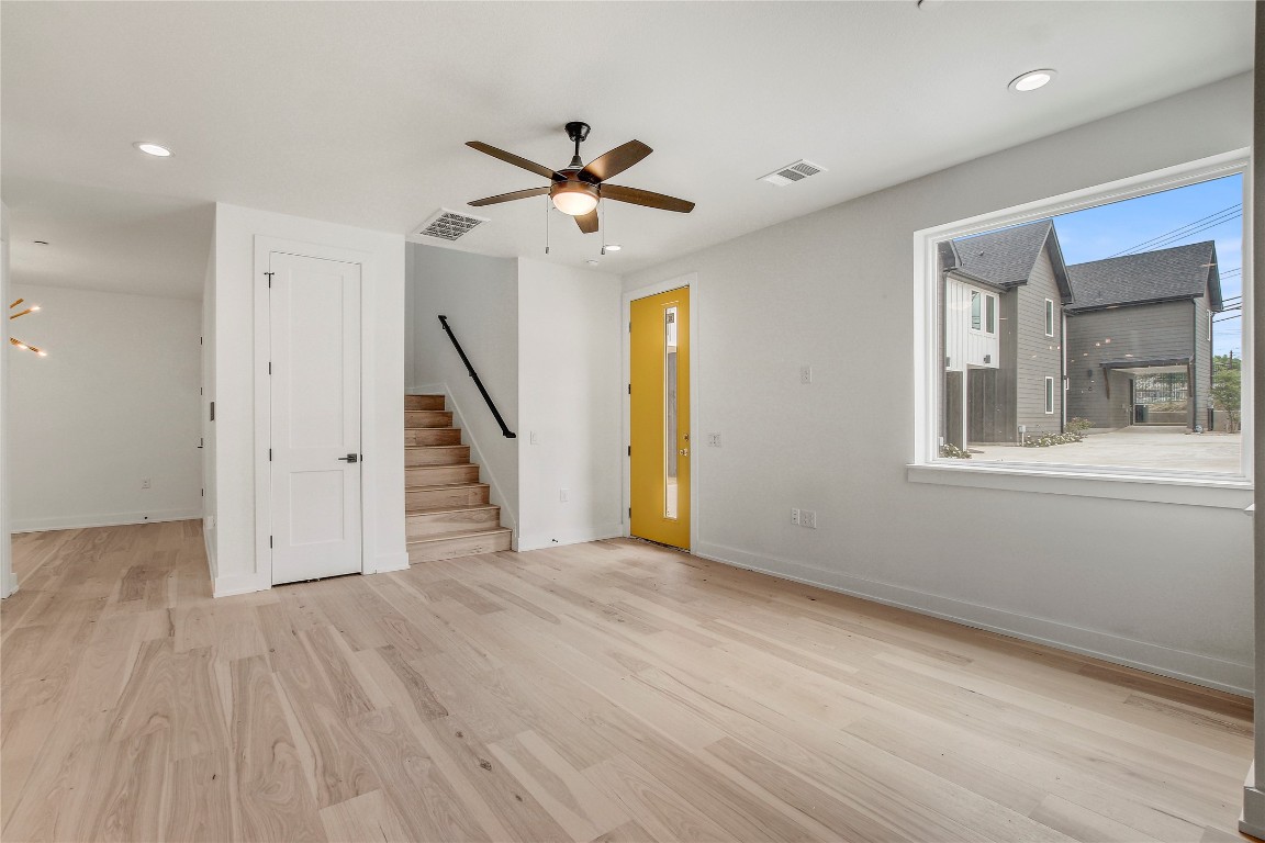 4127 East 12th Street, Unit 2 Austin, TX 78721 - Photo 11 of 28 Unfurnished room with stairs, ceiling fan, baseboards, wood finished floors, and recessed lighting