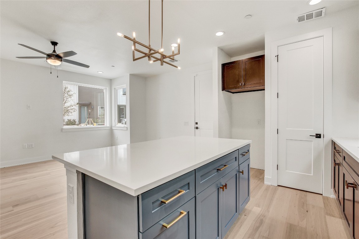 4127 East 12th Street, Unit 2 Austin, TX 78721 - Photo 20 of 28 Kitchen featuring light wood finished floors, a ceiling fan, recessed lighting, light countertops, and a kitchen island