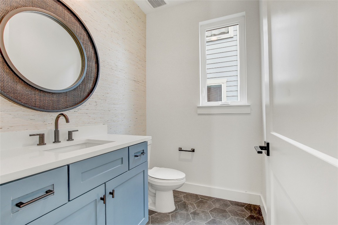 4127 East 12th Street, Unit 2 Austin, TX 78721 - Photo 22 of 28 Half bath featuring baseboards, vanity, toilet, wallpapered walls, and tile patterned flooring