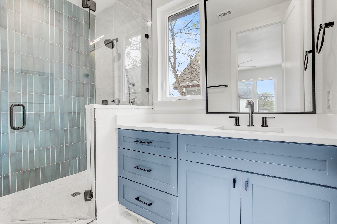 4127 East 12th Street, Unit 2 Austin, TX 78721 - Photo 26 of 28 Full bath with vanity, a stall shower, and marble finish floors