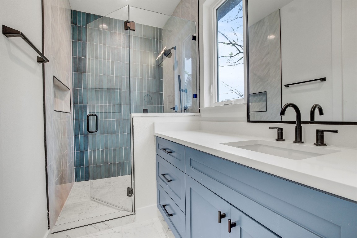 4127 East 12th Street, Unit 2 Austin, TX 78721 - Photo 27 of 28 Full bath with vanity, a stall shower, and marble look tiles