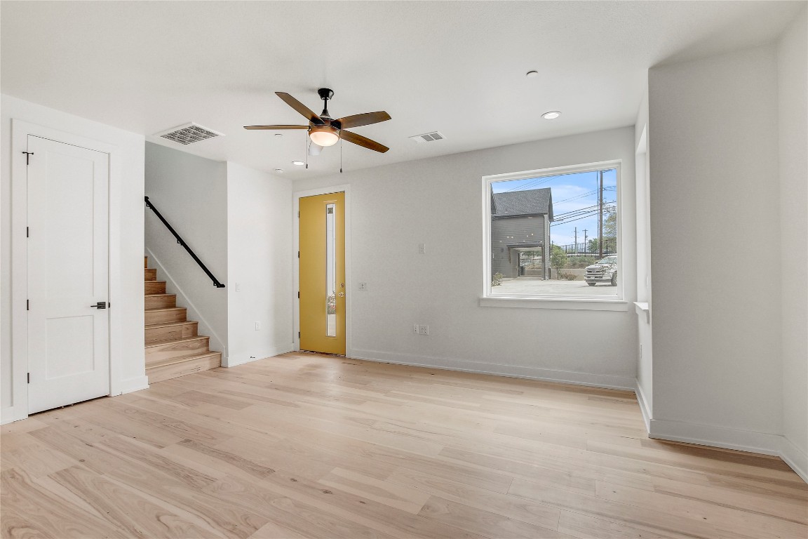 4127 East 12th Street, Unit 2 Austin, TX 78721 - Photo 10 of 28 Spare room featuring light wood-style floors, stairway, a ceiling fan, baseboards, and recessed lighting