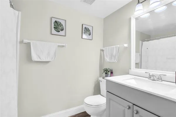 a bathroom with a granite countertop sink mirror vanity and toilet