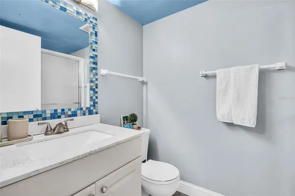 a bathroom with a granite countertop sink mirror vanity and toilet