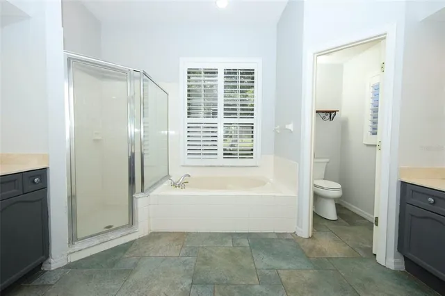 a kitchen with stainless steel appliances granite countertop a refrigerator and white cabinets