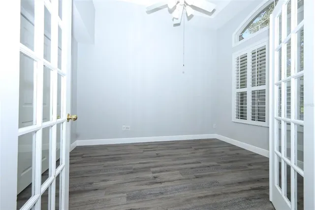 a view of an empty room with a window and a ceiling fan