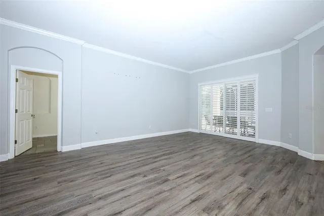 a view of empty room with a window and wooden floor