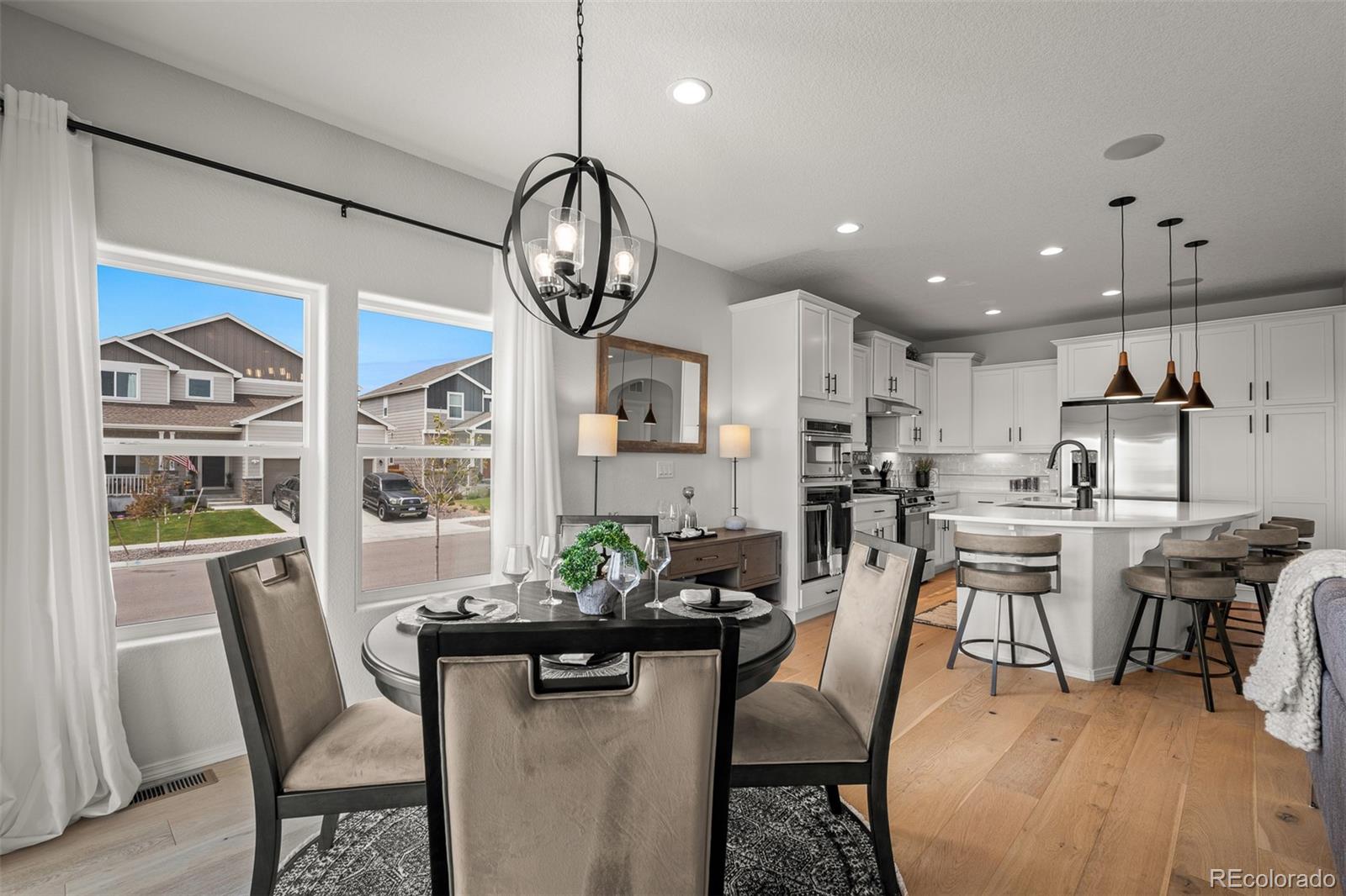 13410 New Ranch Drive Peyton, CO 80831 - Photo 18 of 50 a view of a dining room with furniture a kitchen and chandelier