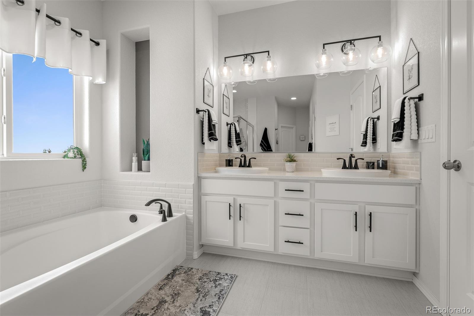 13410 New Ranch Drive Peyton, CO 80831 - Photo 23 of 50 a bathroom with a double vanity sink mirror and bathtub