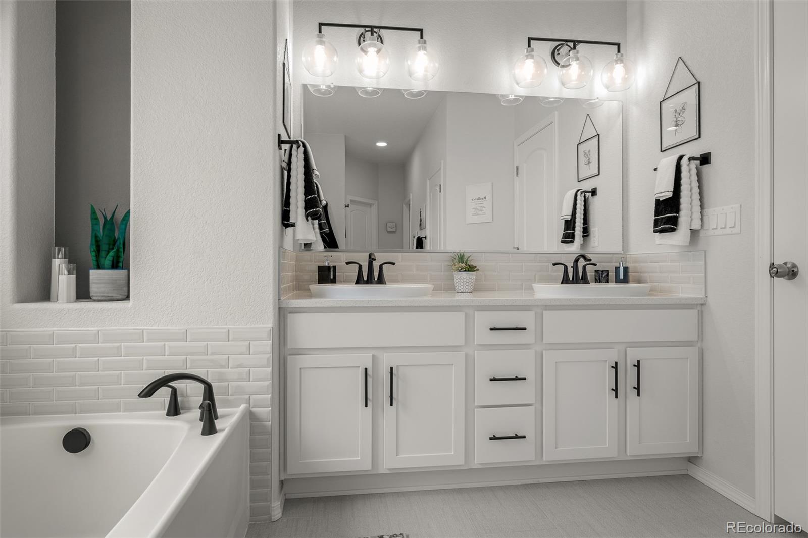 13410 New Ranch Drive Peyton, CO 80831 - Photo 24 of 50 a bathroom with a sink double vanity and a mirror