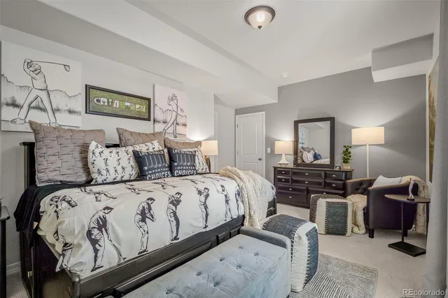 a bedroom with a bed and dresser with mirror