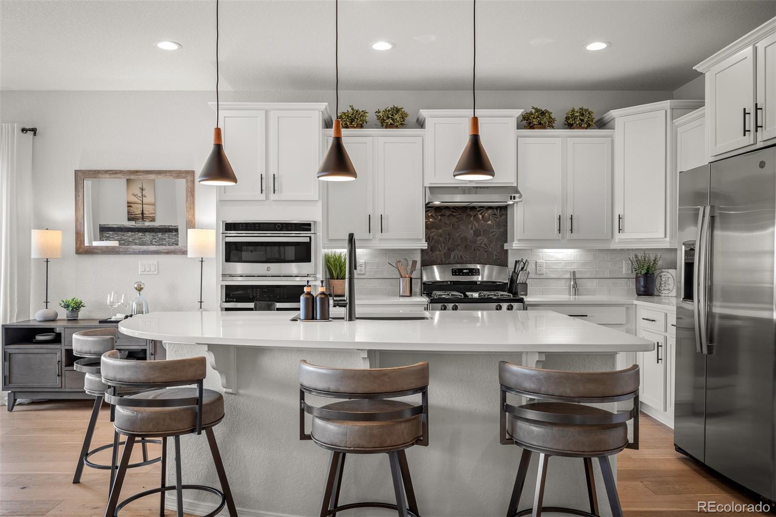 13410 New Ranch Drive Peyton, CO 80831 - Photo 6 of 50 a kitchen with stainless steel appliances granite countertop a refrigerator a stove a oven a sink and chairs