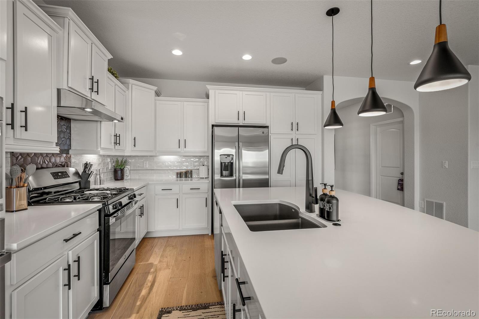 13410 New Ranch Drive Peyton, CO 80831 - Photo 8 of 50 a kitchen with stainless steel appliances granite countertop a sink a stove and a refrigerator