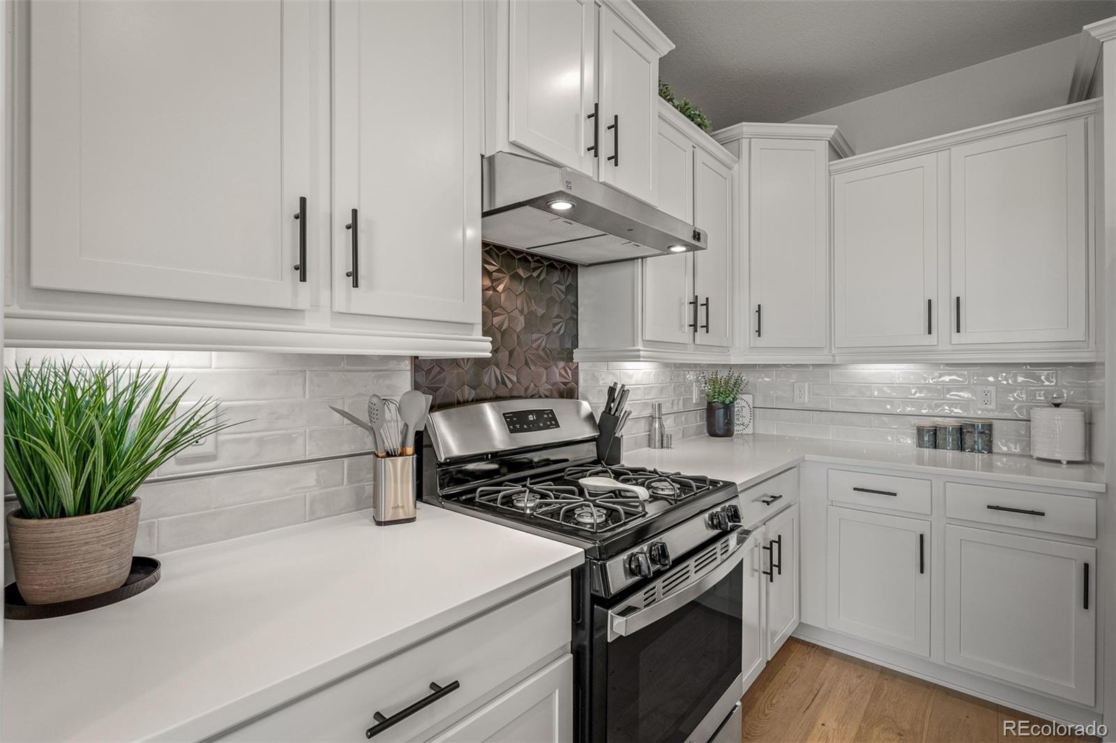 13410 New Ranch Drive Peyton, CO 80831 - Photo 9 of 50 a kitchen with stainless steel appliances a white stove top oven and white cabinets