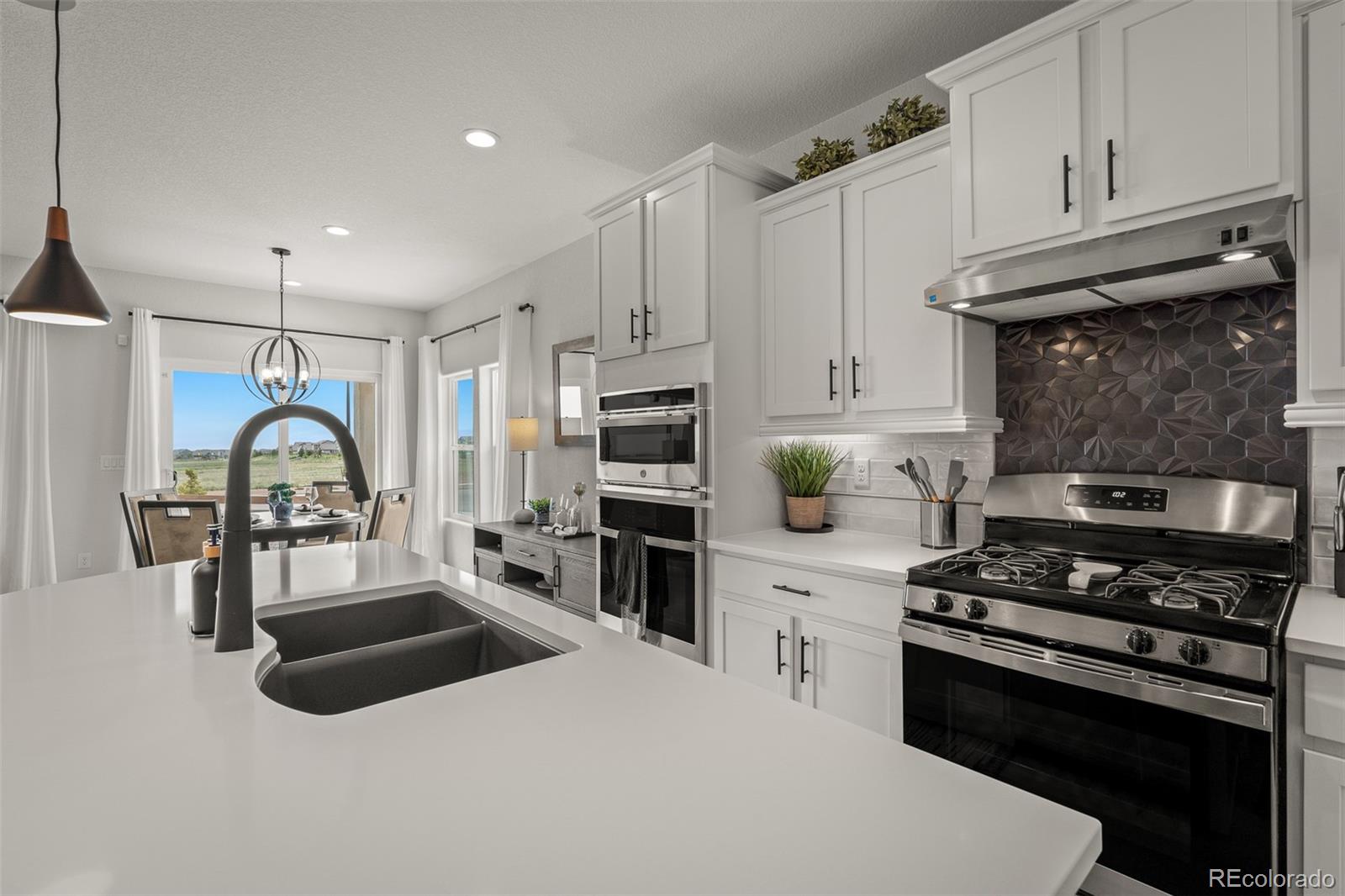 13410 New Ranch Drive Peyton, CO 80831 - Photo 10 of 50 a kitchen with granite countertop a stove and a sink