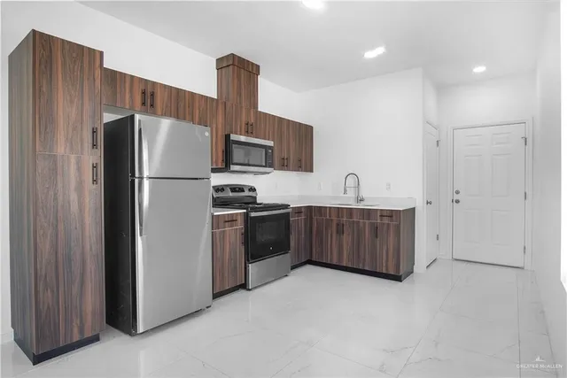a kitchen with stainless steel appliances a refrigerator and a stove top oven