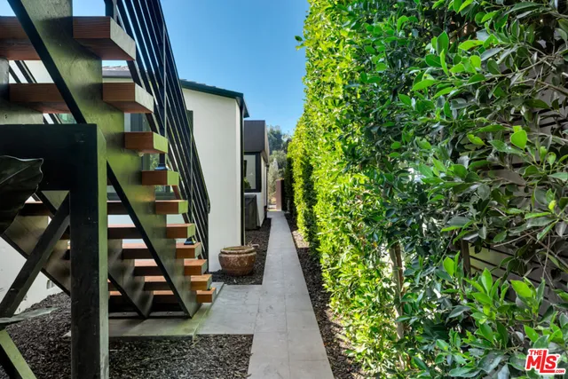 a view of a white house in front of a big yard