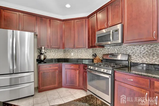 a kitchen with granite countertop wooden cabinets and stainless steel appliances