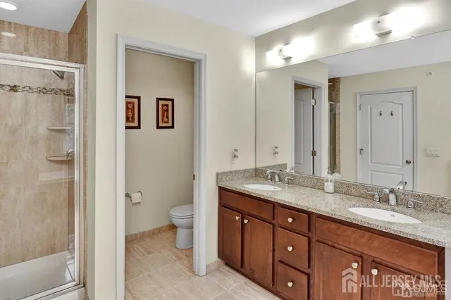 a bathroom with a granite countertop sink toilet and shower
